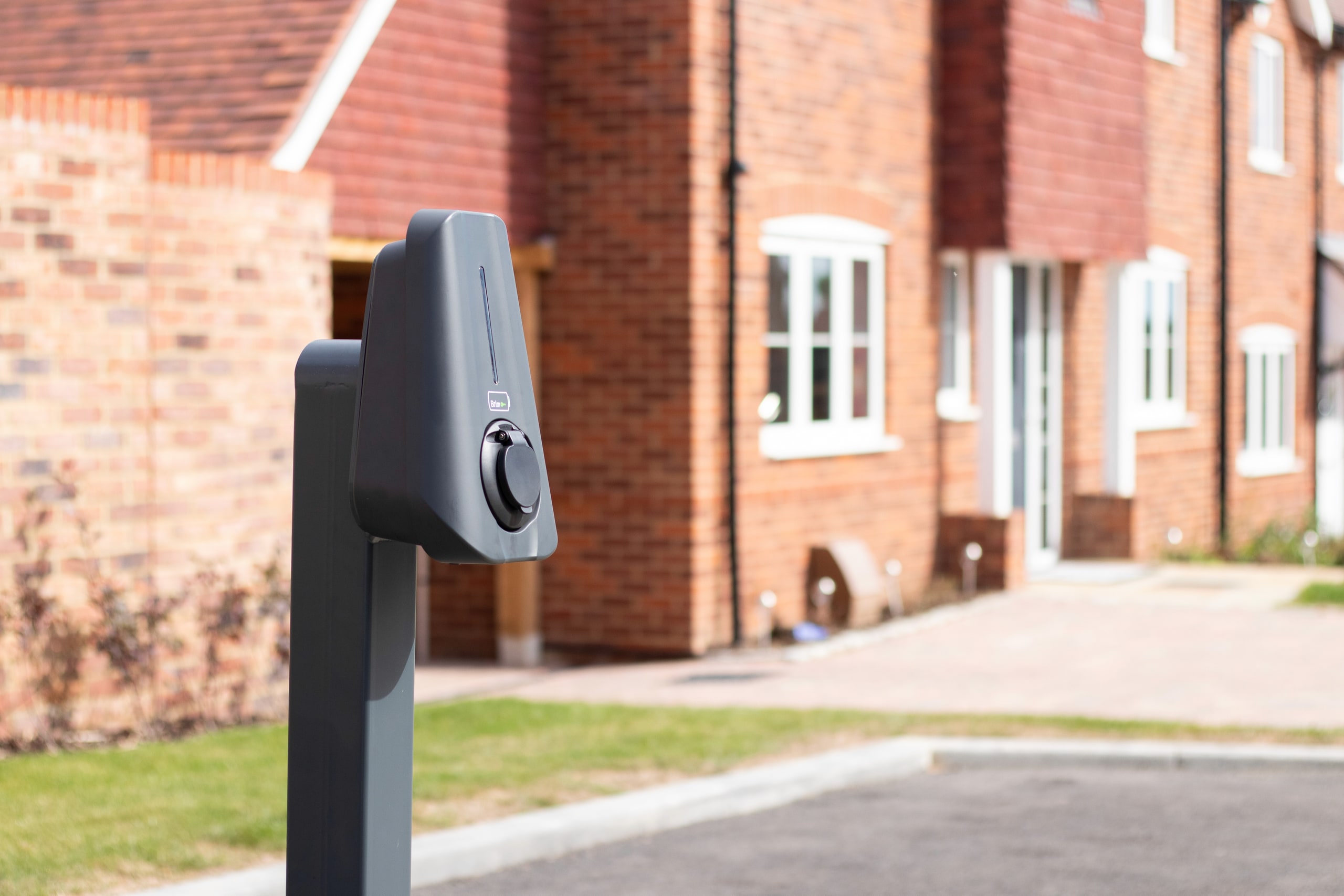 Close up of Brim Smart EV Charger in front of a gravel path on a British countryside new build site