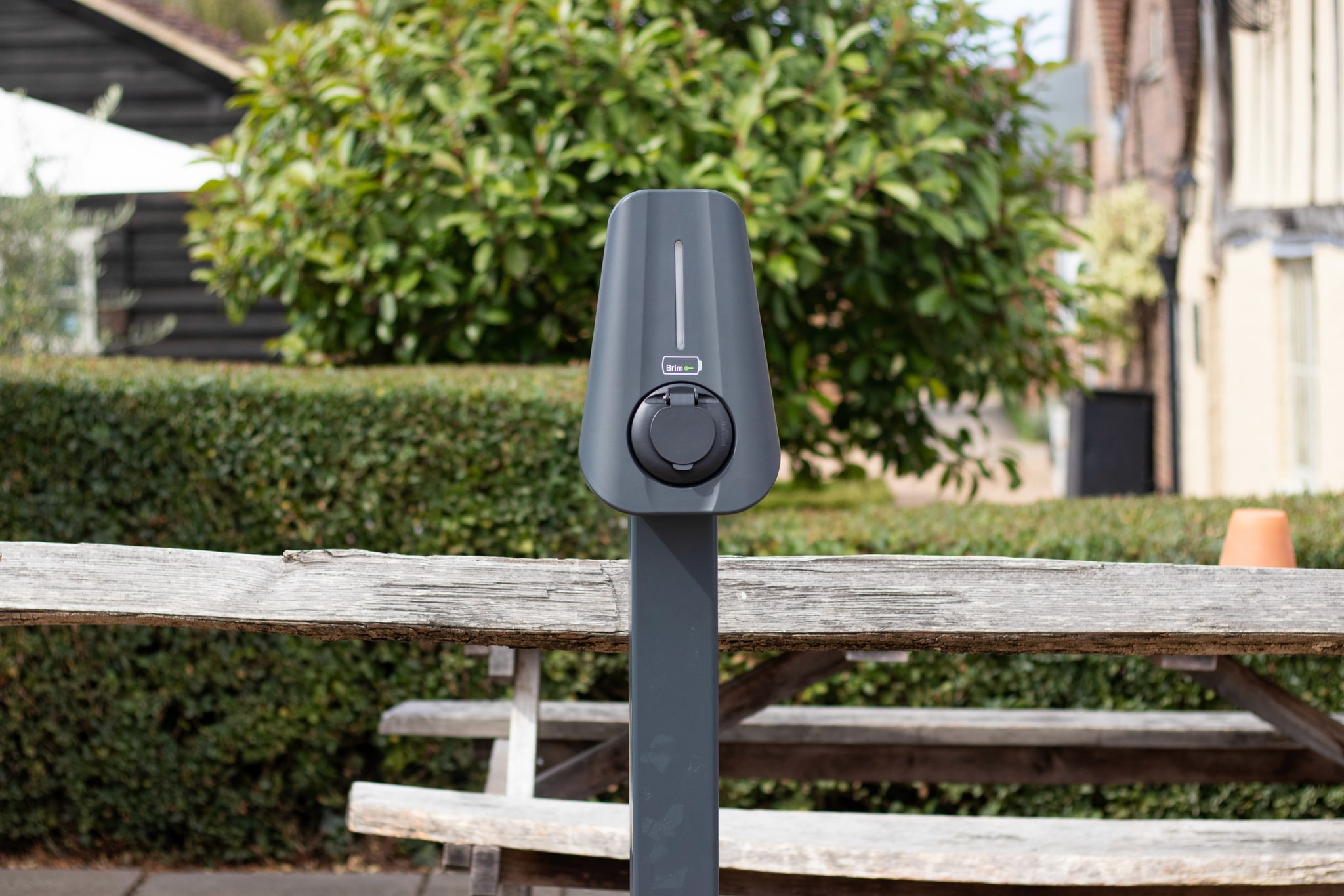A post mounted Brim Smart EV Charger in front of a new build home
