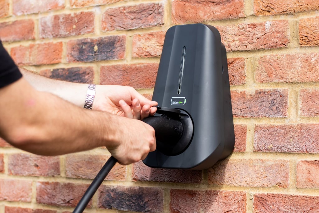Person plugging charging cable into a Brim Smart EV Charger