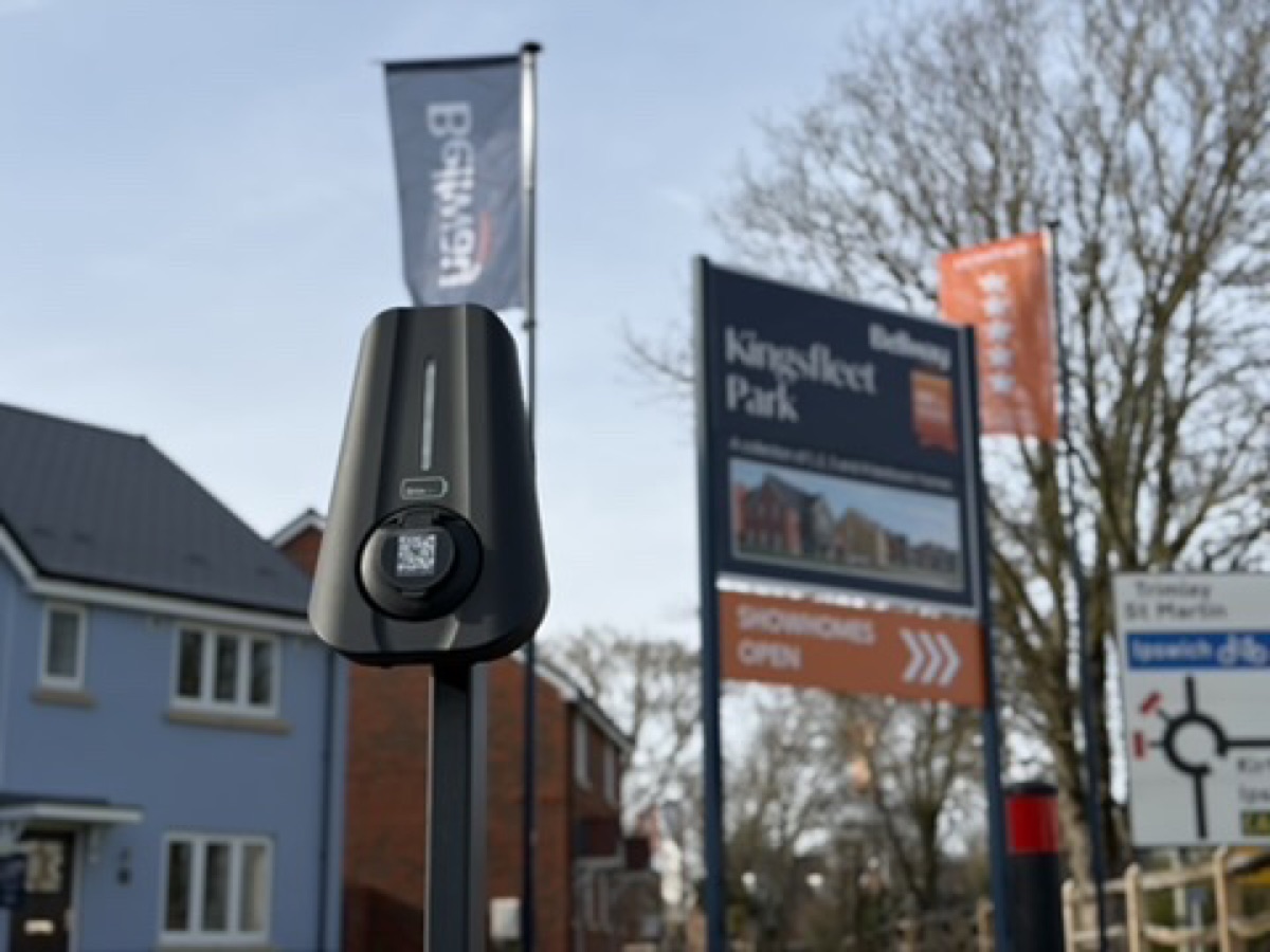 A Brim charger on a post beside the signage of a new housing development